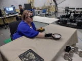 A research team member who is blind uses acoustic touch to locate and reach for an item on the table.