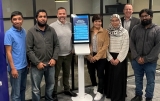 Warrick Flower (right rear) and team members from Optimation gathered around the newly unveiled kiosk, a key component of the Connect solution designed to enhance accessibility