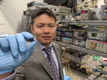 Mike Xu with the integrated optical microcomb chip