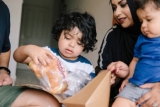 A Canberra family opens a package delivered by drone.