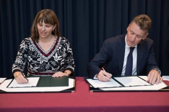 DFAT deputy secretary Penny Williams and Vocus Group managing director and chief executive Kevin Russell signing the contract. 